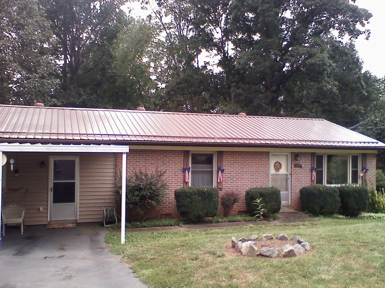 Bronze metal roof and carport on a brick ranch home — Roof Repair work by our crew in Huntsville